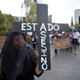 A protestors carries a sign reading "Assassin state."